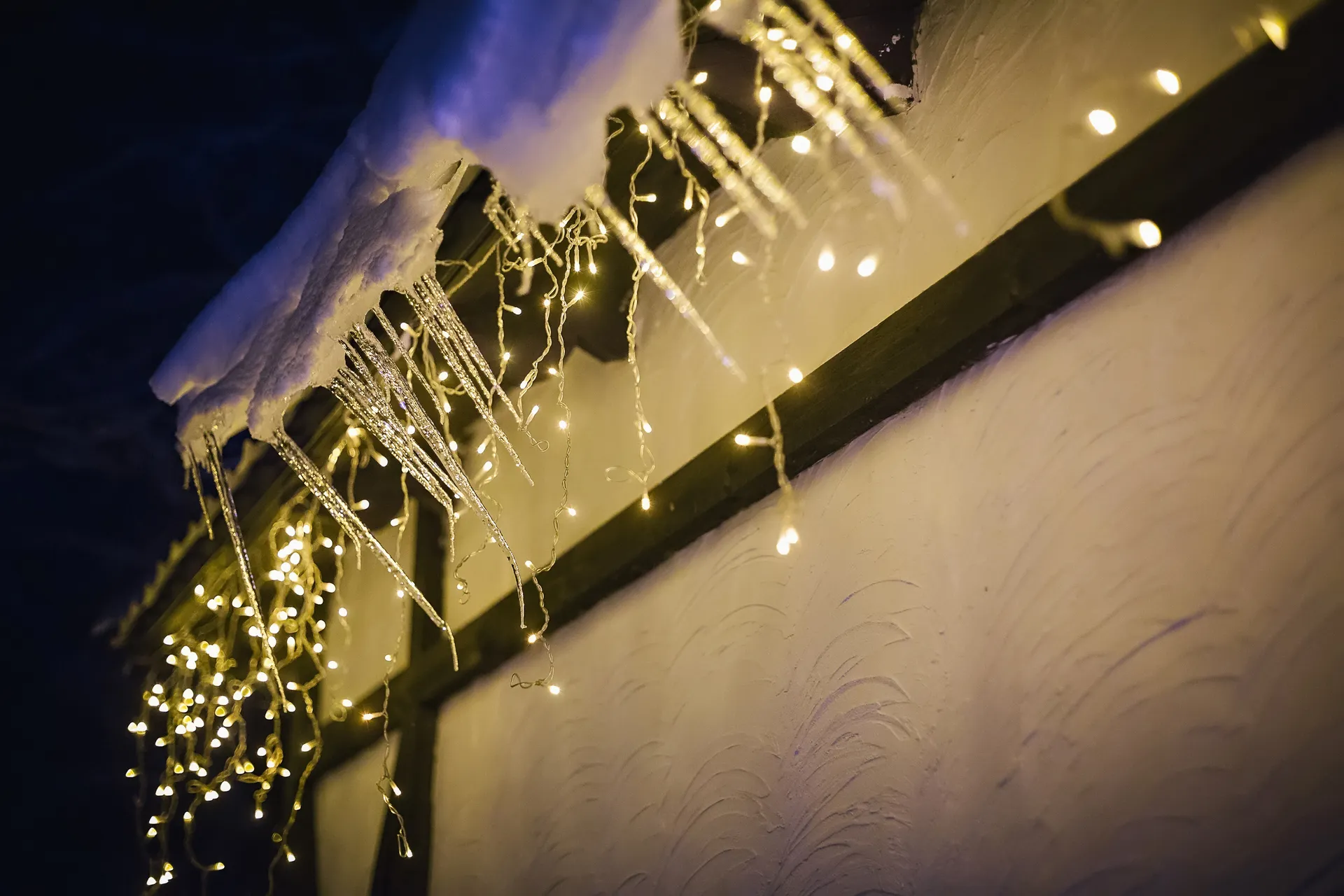 Icicle Christmas lights hanging from a roofline