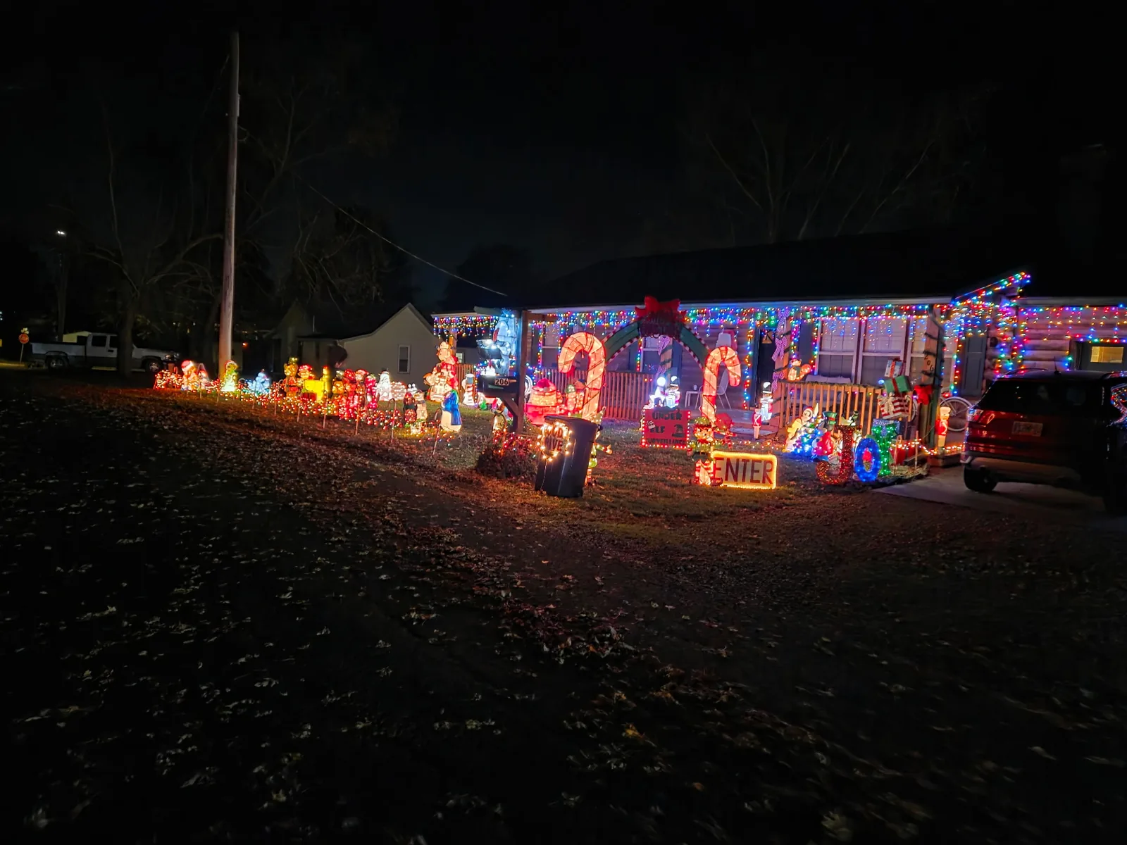 A house outlined in lights with blow molds along the drive