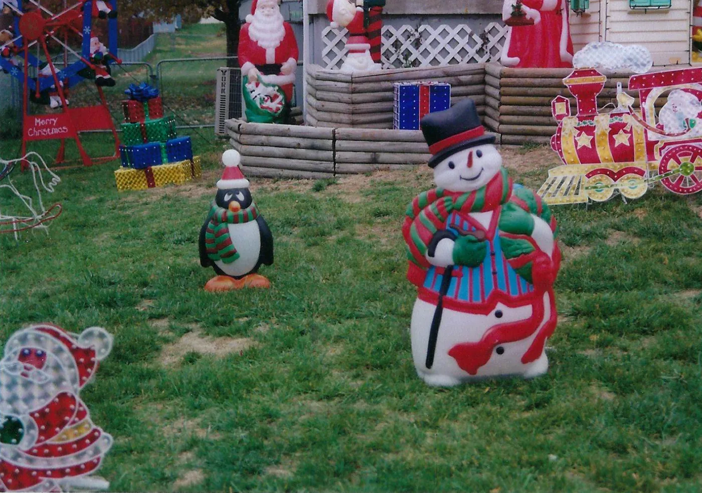 Blow molds across the yard in 2006: a snowman, a penguin, and a toy train