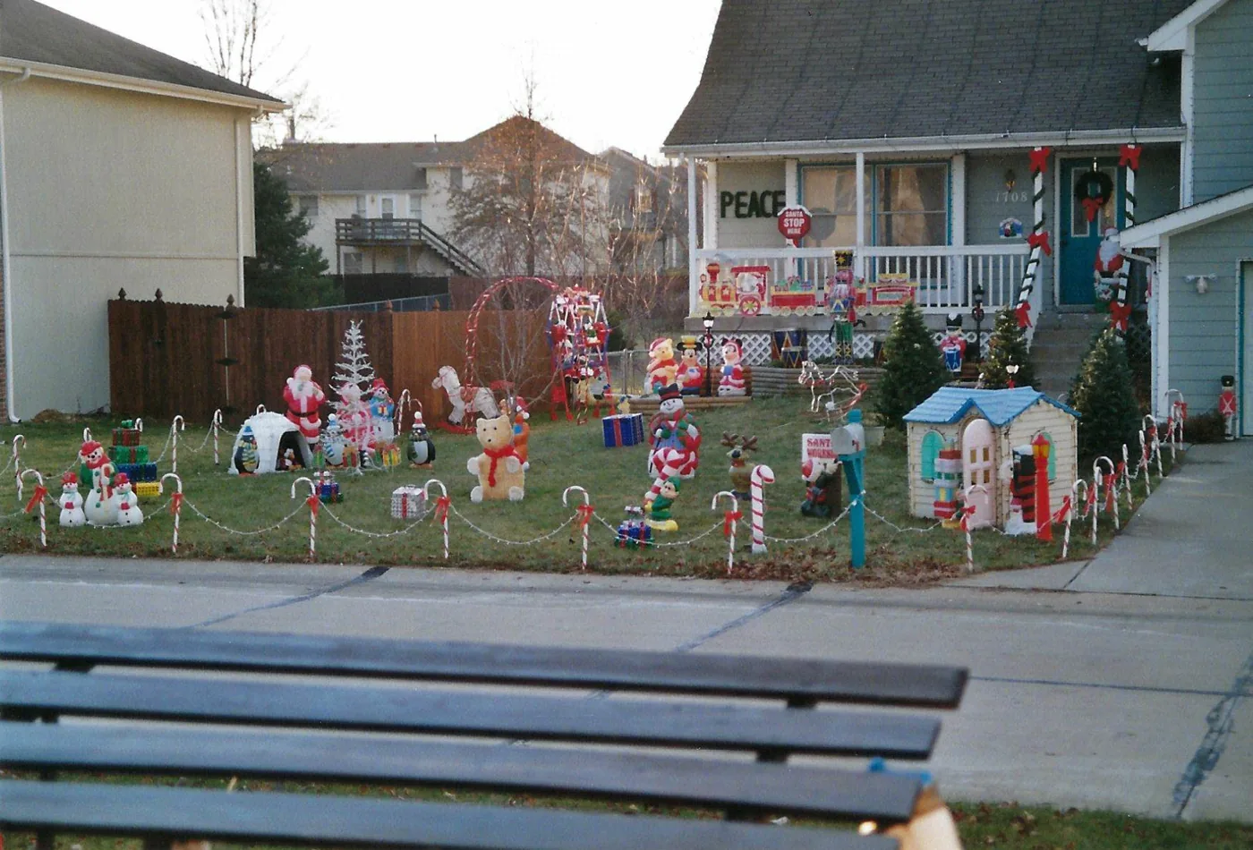 The Kearney yard full of blow molds and candy canes, seen past a park bench in 2008